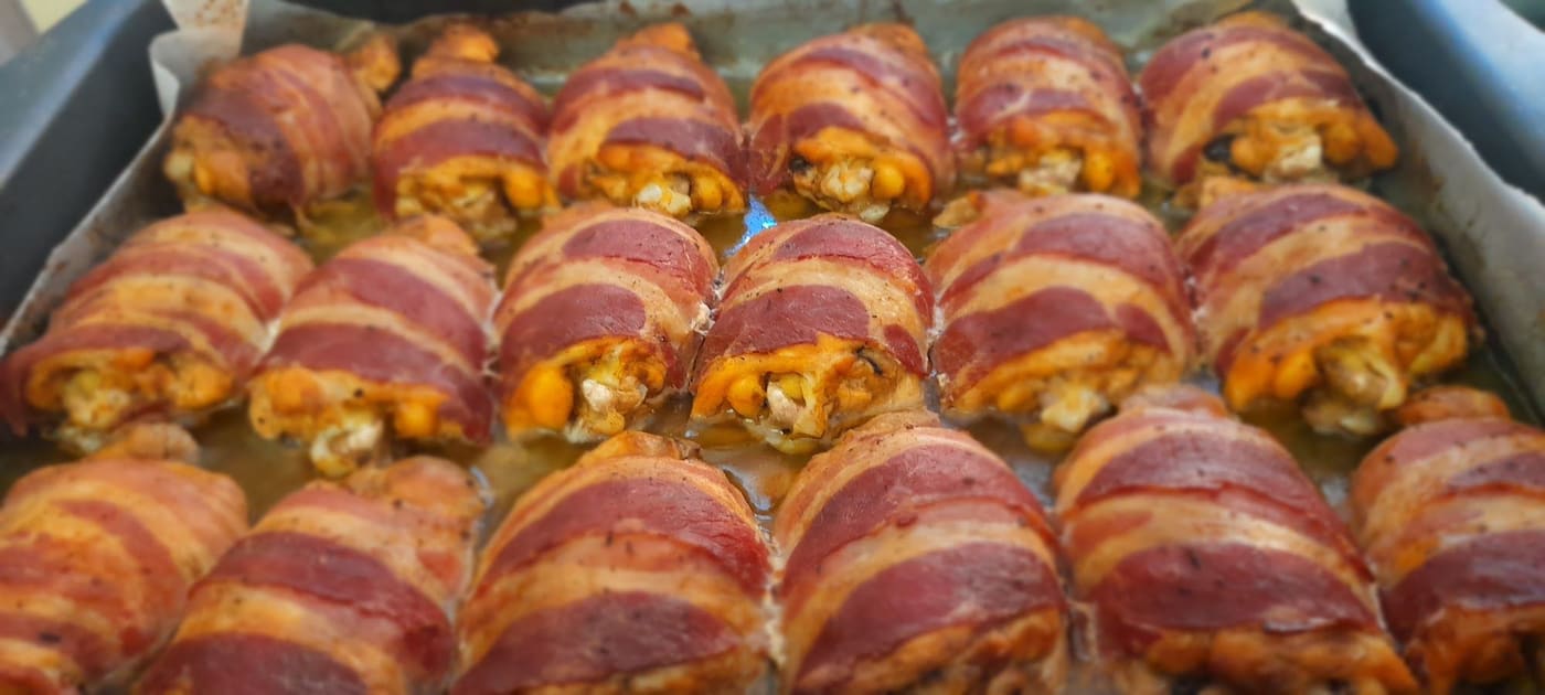 Le sovraccosce avvolte nella pancetta, in fila nella teglia.
